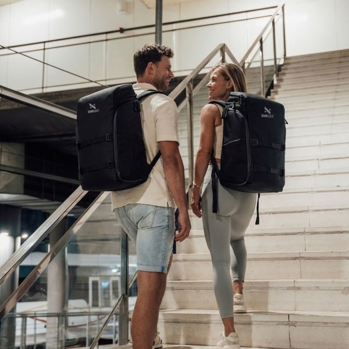 Zeeksack - Mann og kvinne med The Organizer 30L på ryggen på vei opp en trapp.