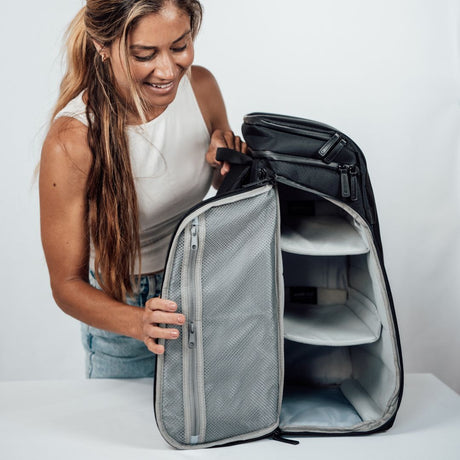 Kvinne viser frem Zeeksack Organizer-ryggsekken og demonstrerer funksjoner.