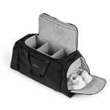 En svart duffelbag med organiserte rom og eget skofag med hvite sko.