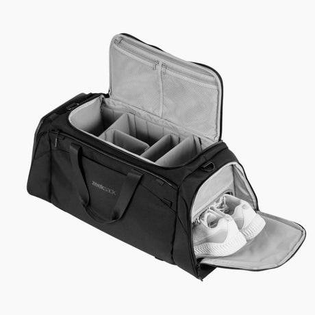 En svart duffelbag med organiserte rom og eget skofag med hvite sko.