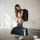 Zeeksack - Kvinne med The Organizer 30L på ryggen og The Weekender 50L i hånden.