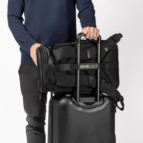Ryggsekken festet på trillekoffert med stropp – perfekt for reise.