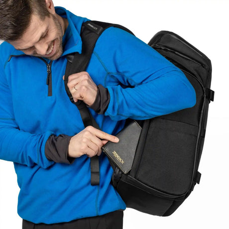 Person viser frem en skjult sikkerhetslomme med glidelås bak på Zeeksack Organizer.