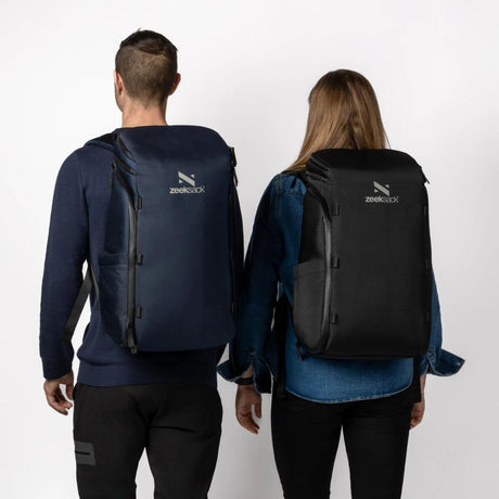 Sort og blå Zeeksack bæres av mann og kvinne – sett bakfra for størrelsesreferanse.