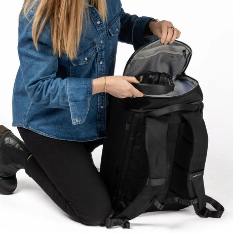 Person legger hodetelefoner i topprommet på Zeeksack Organizer.